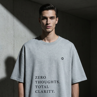 Person wearing a gray t-shirt with text 'ZERO THOUGHTS. TOTAL CLARITY.' in a dark setting.