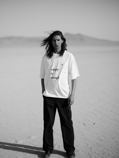 Person wearing a white t-shirt with text in a desert setting